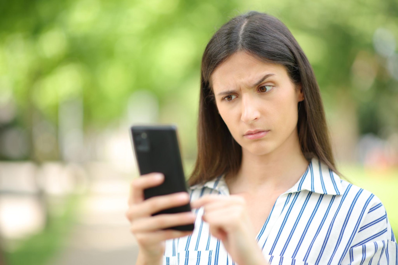A candidate examines her phone with suspicion: the first reflex against fake castings — verify before you trust